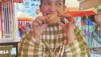 Pose Enzy menikmati bomboloni tampak menggemaskan. Bomboloni ternasuk jenis donat yang tak memiliki lubang, tapi terdapat isian krim di dalamnya. Foto: Instagram @enzystoria
