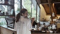 Enzy terlihat menyukai kopi. Diperjelas ketika ia berpose di depan meja barista sambil memegang segelas es Americano. Foto: Instagram @enzystoria