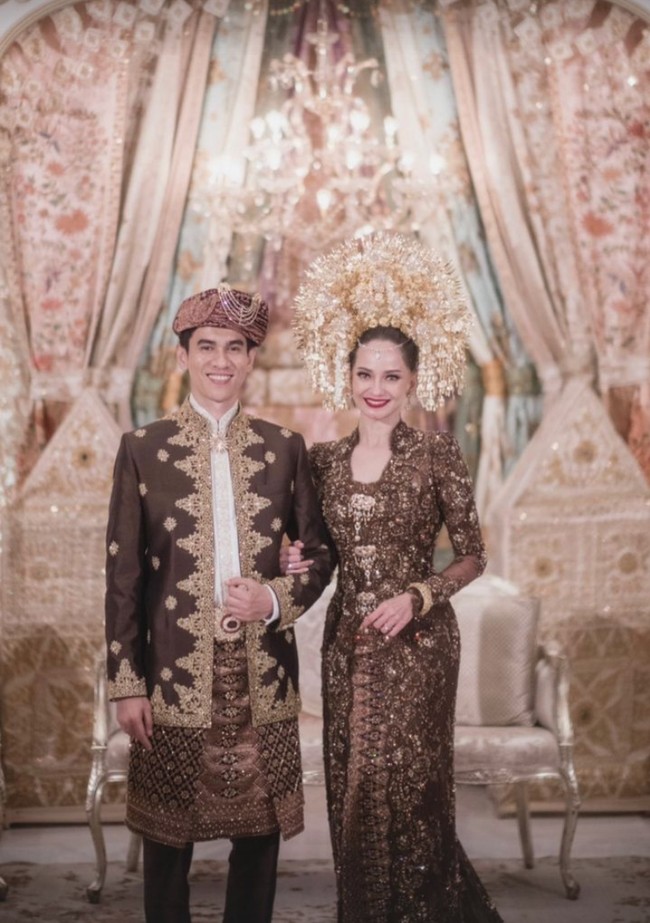 Saat akad nikah, Enzy Storia mengenakan kebaya modern warna cokelat yang dihiasi ribuan payet, kristal serta manik-manik, memberi kesan mewah. Kebaya dipadukan dengan kain songket berhias sulaman benang emas. Foto: Instagram