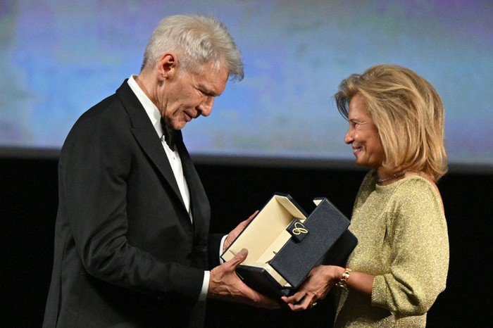 CANNES, FRANCE - MAY 18: Harrison Ford receives an honorary Palme D'Or from Iris Knobloch during the 76th annual Cannes film festival at Palais des Festivals on May 18, 2023 in Cannes, France. (Photo by Stephane Cardinale - Corbis/Corbis via Getty Images)