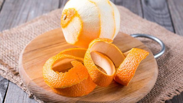 A peeled orange on the wooden background