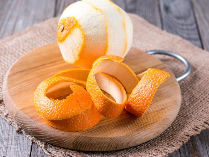 A peeled orange on the wooden background