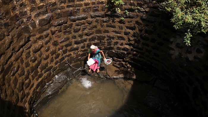 Luar Biasa! Wanita di India Turun-Naik Sumur Demi Air Bersih Women lower plastic containers attached to a rope to draw water from a well in Telamwadi, near Mumbai, India, May 16, 2023. REUTERS/Francis Mascarenhas TPX IMAGES OF THE DAY