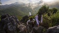 Pengunjung menaiki batuan di situs Geopark Meratus puncak bukit Langara, Kecamatan Loksado, Kabupaten Hulu Sungai Selatan, Kalimantan Selatan, Sabtu (20/5/2023). 