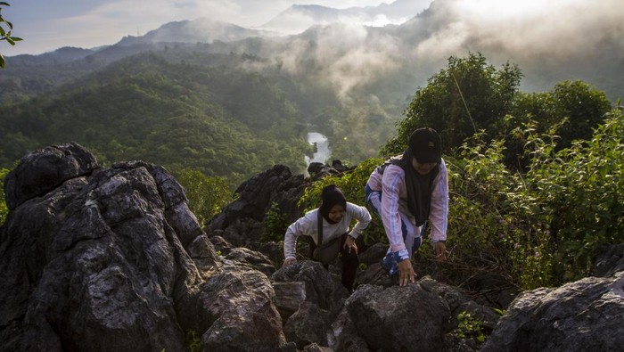 Pengunjung menaiki batuan di situs Geopark Meratus puncak bukit Langara, Kecamatan Loksado, Kabupaten Hulu Sungai Selatan, Kalimantan Selatan, Sabtu (20/5/2023). Badan Pengelola Geopark Meratus Provinsi Kalimantan Selatan membuat empat rute untuk dinikmati wisatawan yaitu rute Barat, Timur, Selatan dan Utara dengan total 54 situs Geopark Meratus untuk mempersiapkan diri masuk dalam jajaran Unesco Global Geopark (UGG) serta sebagai upaya meningkatkan perekonomian masyarakat setempat. ANTARA FOTO/Bayu Pratama S/aww..