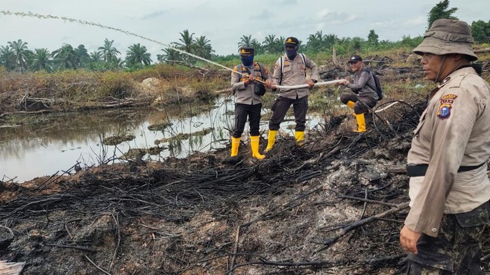 Polisi memadamkan lokasi lahan terbakar di Rohil (Foto: Dok Humas Polda Riau)