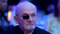 Salman Rushdie muncul dengan setelan jas dan kacamata. Foto: Getty Images for PEN America/Bryan Bedder