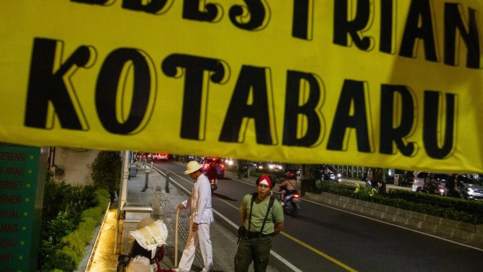 Tempat Ini Jadi Alternatif Wisata Malam Selain Malioboro di Yogyakarta Warga mengenakan pakaian pejuang kemerdekaan berdiri di kawasan Kotabaru, Yogyakarta, Jumat (19/5/2023). Pemerintah Kota Yogyakarta menata kawasan Kotabaru sebagai destiasi wisata malam Yogyakarta yang menawarkan wisata sejarah bangunan cagar budaya sebagai alternatif selain Malioboro dan Tugu. ANTARA FOTO/Hendra Nurdiyansyah/rwa.