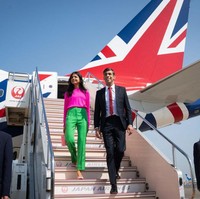 Saat mendarat di Tokyo, Jepang bersama Rishi Sunak, Akshata Murty tampil dengan busana warna fuschia dari brand Chinti & Parker seharga 95 poundsterling. Dia memadukan blousenya dengan celana hijau terang dari ME+EM seharga 165 poundsterling. Foto: Dok. Getty Images