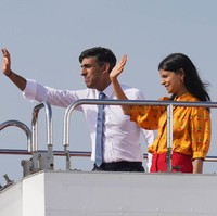 Akshata Murty mendampingi suaminya Perdana Menteri Inggris Rishi Sunak menghadiri KTT G7 yang digelar di Jepang. Saat berangkat dari Tokyo menuju Hiroshima, Akshata tampil dengan kemeja oranye motif cherry. Kemeja yang dipakainya itu merupakan keluaran brand Inggris Lisou dan dijual seharga 250 poundsterling. Foto: Dok. Getty Images