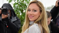 Dengan rambut yang dicat blonde, ia mengenakan dress terusan yang memperlihatkan perutnya.  Foto: Corbis via Getty Images/Stephane Cardinale - Corbis