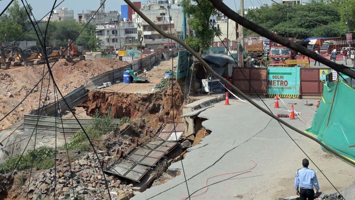 Jalanan di Delhi Tenggelam Sedalam 50 Kaki, Begini Penampakannya NEW DELHI, INDIA MAY 20: A portion of road caved during the excavation work near under construction Maidan Garhi metro station in South Delhi, road has sunk around 50 feet deep, on May 20, 2023 in New Delhi, India. No injuries have been reported in the incident. (Photo by Vipin Kumar/Hindustan Times via Getty Images)