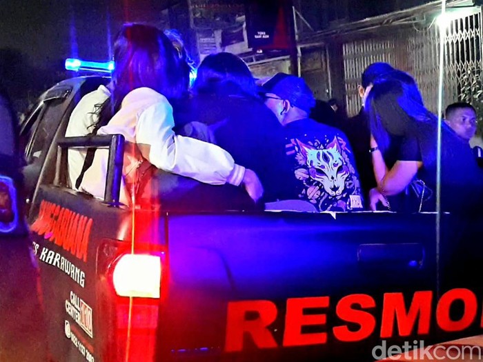 Polisi saat mengangkut pasangan yang terjaring razia di indekos Karawang