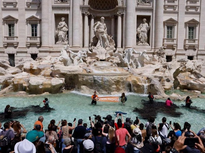 Climate activists pour vegetable charcoal in the Trevi Fountain water, during a demonstration against fossil fuels, in Rome, Italy May 21, 2023 in this image obtained from social media. Allesandro Penso/MAPS via REUTERS