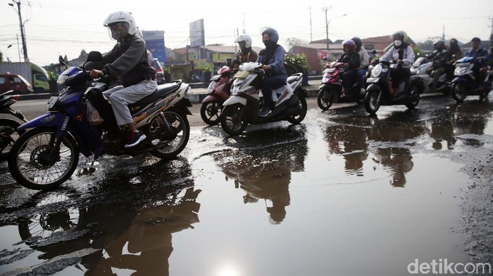 Pengendara melintasi jalan rusak dk Jl Jenderal Sudirman-Jl I Gusti Ngurah Rai di Kranji, Kota Bekasi, Jawa Barat, Senin (22/5/2023). Jalan rusak sepanjang hampir 200 meter ini sudah lama rusak dan tidak diperbaiki hingga kini. Direncanakan jalan ini akan diperbaiki pada 17/5/2023 namun hingga hari ini tak kunjung dilaksanakan. Rencananya jalan yang diperbaikan itu tidak akan disertai pembangunan drainase (got) di lokasi.