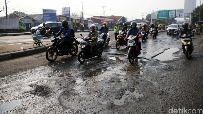 Pengendara melintasi jalan rusak dk Jl Jenderal Sudirman-Jl I Gusti Ngurah Rai di Kranji, Kota Bekasi, Jawa Barat, Senin (22/5/2023). Jalan rusak sepanjang hampir 200 meter ini sudah lama rusak dan tidak diperbaiki hingga kini. Direncanakan jalan ini akan diperbaiki pada 17/5/2023 namun hingga hari ini tak kunjung dilaksanakan. Rencananya jalan yang diperbaikan itu tidak akan disertai pembangunan drainase (got) di lokasi.