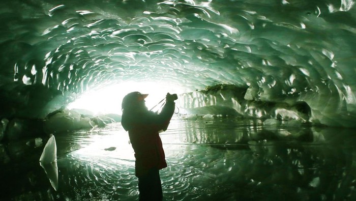 PENBA, CHINA - MAY 21: People visit the ice cave on May 21, 2023 in Penba county, Tibet Autonomous Region of China. The arch-shaped ice cave is 165 meters long, 26 meters wide and 15 meters high, marking the largest in Tibet. (Photo by Wang Jianzhong/VCG via Getty Images)