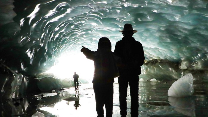 PENBA, CHINA - MAY 21: People visit the ice cave on May 21, 2023 in Penba county, Tibet Autonomous Region of China. The arch-shaped ice cave is 165 meters long, 26 meters wide and 15 meters high, marking the largest in Tibet. (Photo by Wang Jianzhong/VCG via Getty Images)