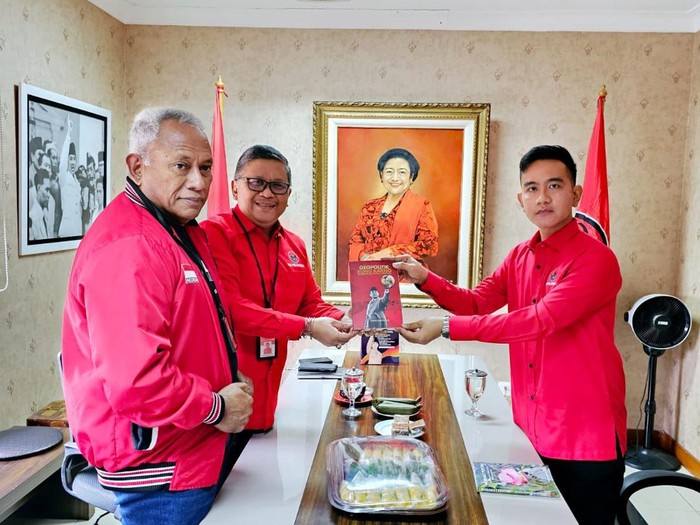 Sekjen PDIP Hasto Kristiyanto memberikan dua buku kepada Wali Kota Solo Gibran Rakabuming Raka di sela-sela pemanggilannya di kantor DPP PDIP, Selasa (22/5/2023).