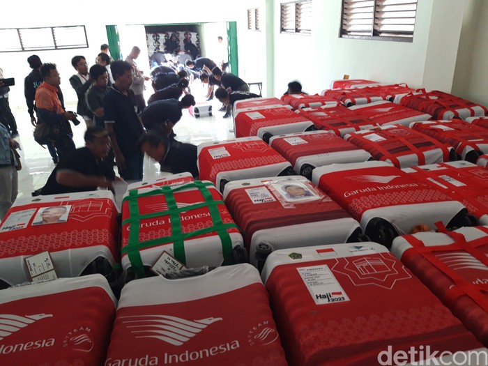 Petugas menurunkan koper milik jemaah calon haji di Asrama Haji Donohudan, Boyolali, Senin (22/5/2023).