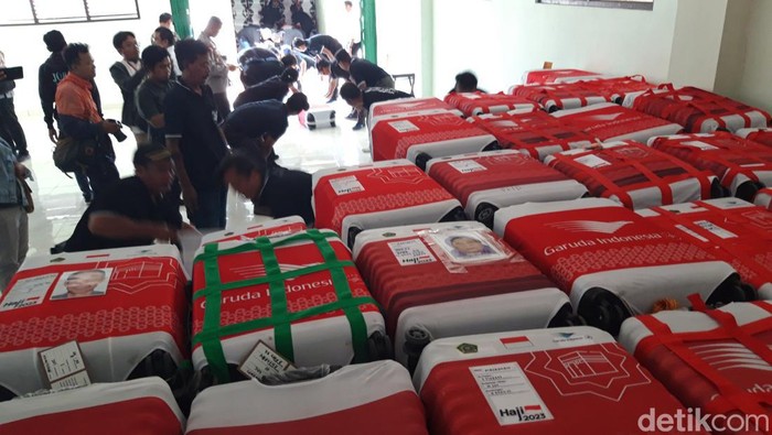 Petugas menurunkan koper milik jemaah calon haji di Asrama Haji Donohudan, Boyolali, Senin (22/5/2023).