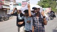 Warga harus berjalan dengan memakai penutup kepala untuk menghindari panas yang berlebihan.