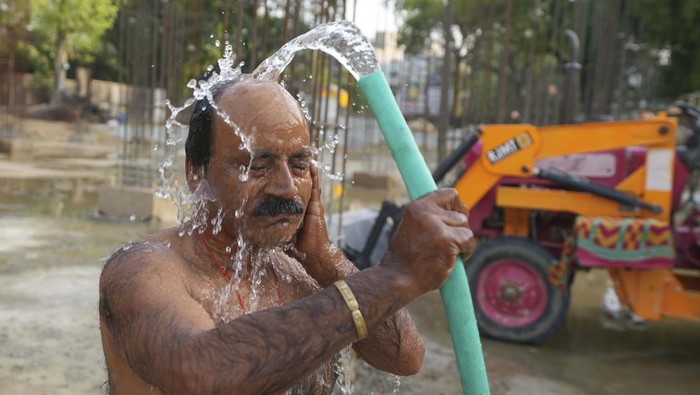 An Indian laborer sleeps on a push cart in the shade of a tree on a hot day in Prayagraj, northern Uttar Pradesh state India, Monday, May 22, 2023. The heat wave in the state is likely to continue for another two days, an Indian Meteorological Department official said. (AP Photo/Rajesh Kumar Singh)