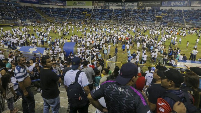 Soccer fans are assisted by others fans at the field of the Cuscatlan stadium in San Salvador, El Salvador, Saturday, May 20, 2023. At least nine people were killed and dozens more injured when stampeding fans pushed through one of the access gates at a quarterfinal Salvadoran league soccer match between Alianza and FAS. (AP Photo/Milton Flores)