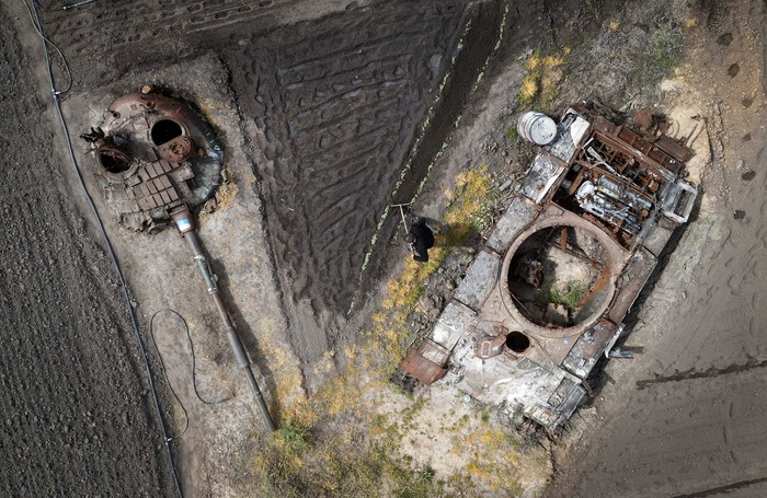 Tank-tank yang rusak akibat perang teronggok di perkebunan Desa Velyka Dymerka, Kyiv, Ukraina. Warga pun berkebun di antara tank-tank yang rusak.