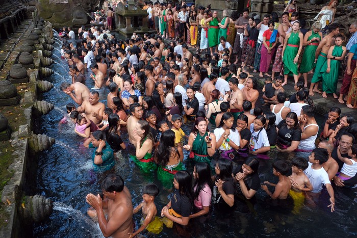Wisatawan mancanegara berbaur dengan umat Hindu yang melakukan ritual melukat atau pembersihan diri pada hari Banyu Pinaruh di Pura Tirta Empul, Tampaksiring, Gianyar, Bali, Minggu (21/5/2023). Ritual tersebut digelar setiap enam bulan sekali yakni sehari setelah Hari Raya Saraswati oleh umat Hindu untuk menyucikan dan membersihkan diri serta pikiran secara spiritual dengan melakukan ritual pembersihan diri di laut maupun sumber mata air suci lainnya. ANTARA FOTO/Nyoman Hendra Wibowo/YU