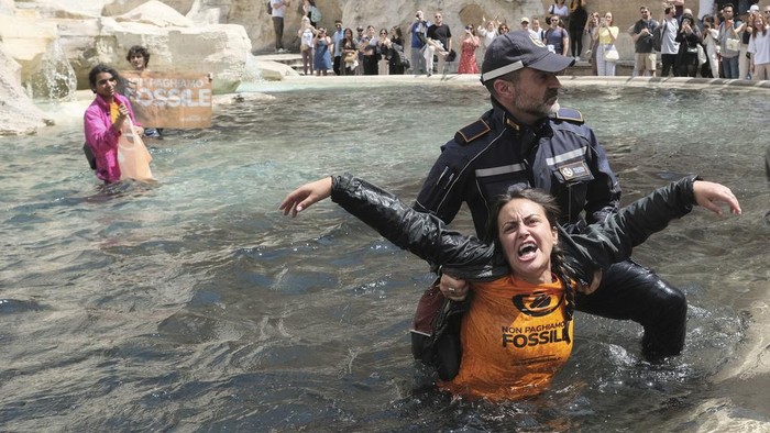 Protes Iklim, Aktivis Lingkungan Ubah Air Mancur Ikon Roma Jadi Hitam Last Generation environmentalists are being taken out after showing a banner against the use of fossil fuels in the Trevi Fountain in Rome, Sunday, May 21, 2023. (Mauro Scrobogna/LaPresse via AP)