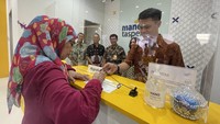 Direktur Finance and Risk Operation Bank Mandiri Taspen, Atta Alva Wanggai, Direktur Utama Bank Mandiri Taspen, Elmamber Sinaga, Direktur Bisnis Bank Mandiri Taspen, Maswar Purnama, Kepala Divisi Distribution and Portfolio Management, Erlinda Rusda saat berbincang dengan nasabah disela pemindahan kantor cabang pembantu Mandiri Taspen Rawamangun di Jakarta, Senin (22/5).  