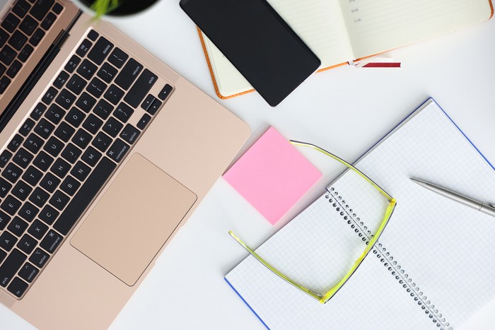 On table laptop smartphone glasses pen and notepad. Online courses for freelancers concept