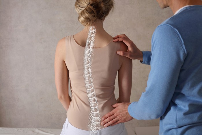 Woman suffering from back ache on the bed, healthcare and problem concept