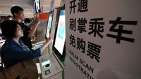 Sejumlah penumpang menyelesaikan pendaftaran pemindaian telapak tangan di layar di sebuah stasiun di Daxing Airport Express, jalur kereta bawah tanah Beijing, di Beijing, China, Minggu (21/5/2023). 