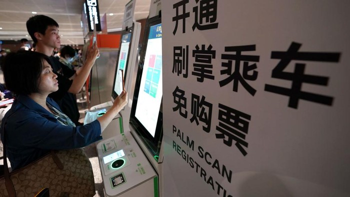 Canggih! Naik Kereta di Beijing Cukup Scan Telapak Tangan BEIJING, CHINA - MAY 21: A passenger shows her palm to pass through a ticket gate at a station on the Daxing Airport Express, a Beijing subway line, on May 21, 2023 in Beijing, China. A designated line of the Beijing Metro pilots a specific check-in service that allows passengers to enter and exit