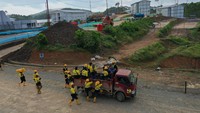 Mereka menunggu jemputan truk yang mengantar ke lokasi proyek dari hunian pekerja konstruksi yang menjadi tempat menginap mereka selama pengerjaan.  
