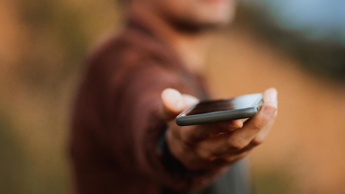 Ilustrasi mencari lowongan kerja melalui handphone.
