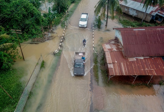 Seorang warga membawa kasur melewati samping rumahnya yang terendam banjir di Kenali Asam Bawah, Kota Baru, Jambi, Selasa (23/5/2023). Banjir akibat kurang berfungsinya sistem drainase setelah hujan deras pada Selasa (23/5) dini hari mengakibatkan seratusan rumah dan beberapa ruas jalan di kota itu terendam air hingga ketinggian setengah meter. ANTARA FOTO/Wahdi Septiawan/tom.