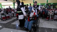 Petugas membantu jemaah calon haji lansia asal Kabupaten Grobogan yang menggunakan kursi roda saat masuk di Asrama Haji Donohudan, Boyolali, Jawa Tengah, Selasa (23/5/2023).