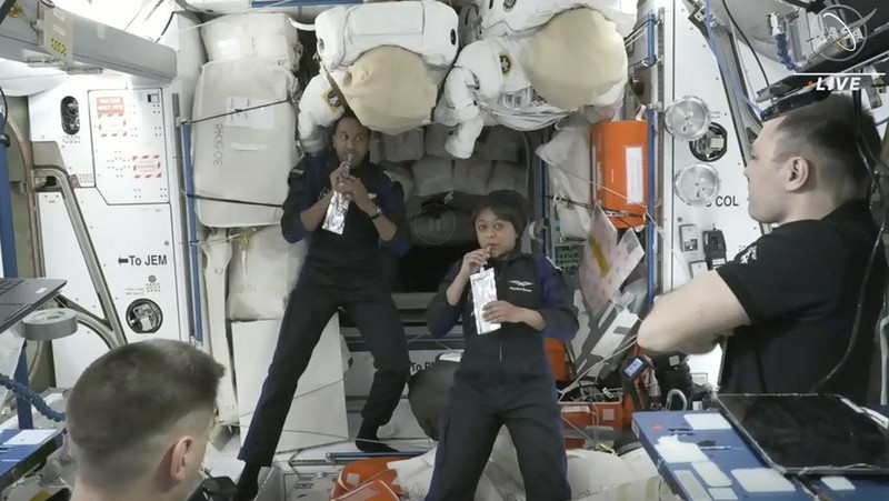 In this image from NASA TV, Ali al-Qarni, second from left, and Rayyanah Barnawi of Saudi Arabia, second right, have a drink alongside two cosmonauts in the International Space Station, Monday, May 22, 2023. The space station rolled out the welcome mat for the two Saudi visitors, including the kingdom's first female astronaut. (NASA TV via AP)