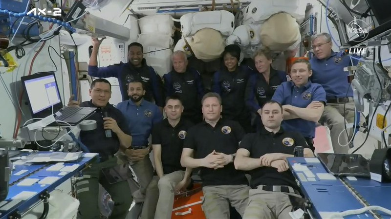 In this image from NASA TV, Ali al-Qarni, second from left, and Rayyanah Barnawi of Saudi Arabia, second right, have a drink alongside two cosmonauts in the International Space Station, Monday, May 22, 2023. The space station rolled out the welcome mat for the two Saudi visitors, including the kingdom's first female astronaut. (NASA TV via AP)