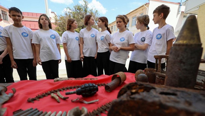 Rusia Beri Latihan Militer ke Anak-anak Sekolah di Crimea Members of Russia's Youth Army military-patriotic movement and other participants attend a demonstration lesson that is part of an extracurricular educational program, which involves weapon training, first aid treatment, camping skills and other courses, in Sevastopol, Crimea, May 19, 2023. REUTERS/Alexey Pavlishak