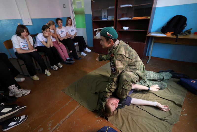 Members of Russia's Youth Army military-patriotic movement and other participants attend a demonstration lesson that is part of an extracurricular educational program, which involves weapon training, first aid treatment, camping skills and other courses, in Sevastopol, Crimea, May 19, 2023. REUTERS/Alexey Pavlishak