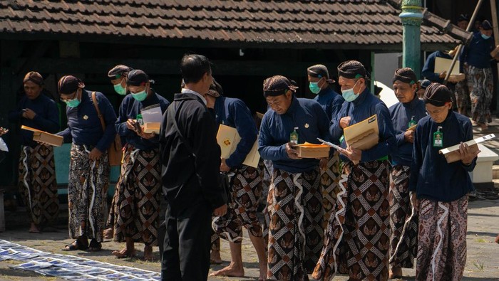 Wisuda Abdi Dalem Keraton Yogyakarta Abdi Dalem Keraton Yogyakarta melihat foto yang dijual seusai prosesi wisuda di Bangsal Magangan, Kompleks Keraton Yogyakarta, DI Yogyakarta, Selasa (23/5/2023). Dalam acara itu sekitar 300 abdi dalem punokawan (masyarakat umum) dan keprajan (pejabat) menerima serat kekancingan atau surat keputusan mengangkat abdi dalem baru, serta menaikkan pangkat. ANTARA FOTO/Andreas Fitri Atmoko/rwa.