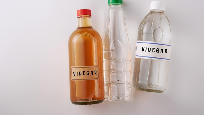 top view two bottles white vinegar and  bottle of apple cider vinegar