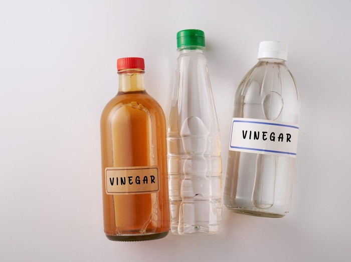 top view two bottles white vinegar and  bottle of apple cider vinegar
