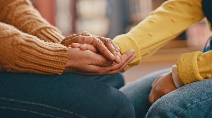 Hands, love and care touching in support, trust or unity for community, compassion or understanding. People holding hands in respect for loss, affection or passion for listening, talk or time