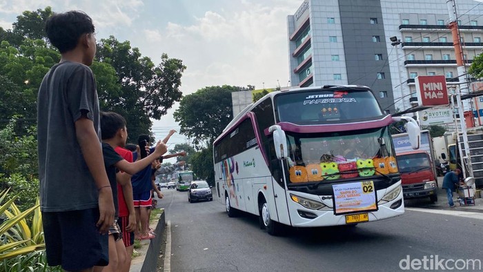 Anak-anak menunggu bus agar menyalakan klakson telolet di Bandung