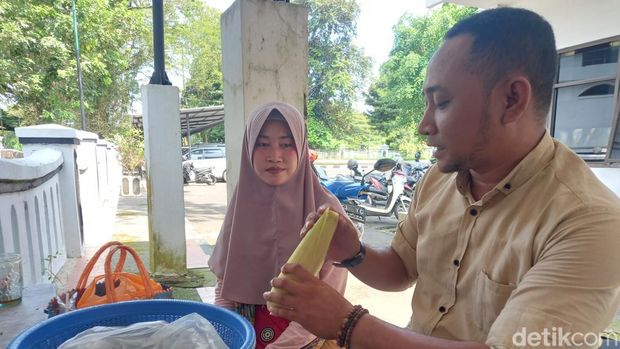 Diana saat melayani pembeli jagung rebusnya.